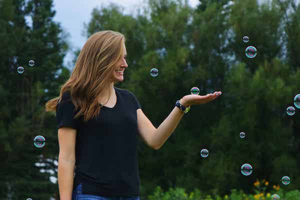 Woman smiling hand touching bubble nature background how to be positive