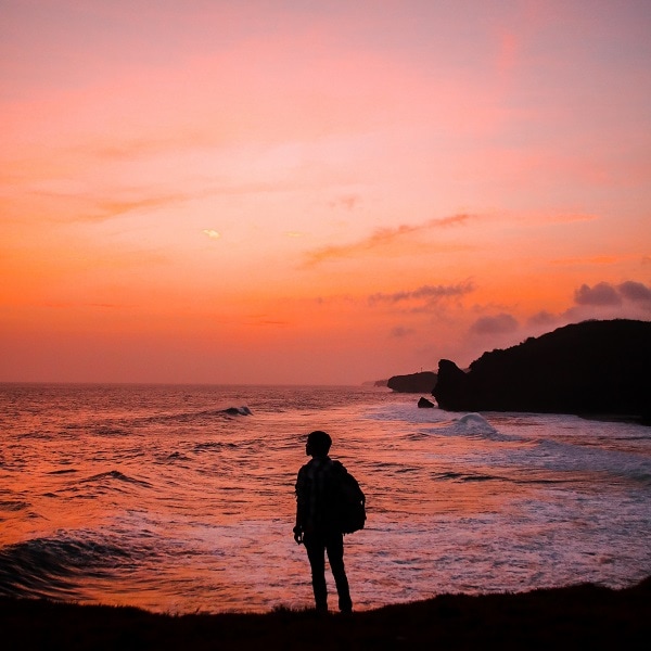 Silhouette man in front of ocean sunset sky 10 ways to end your day right to have a great morning