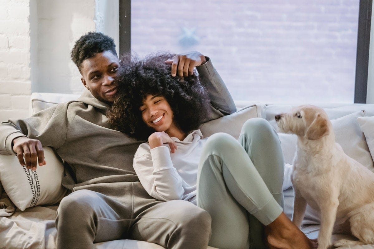 black couple cuddling and dog